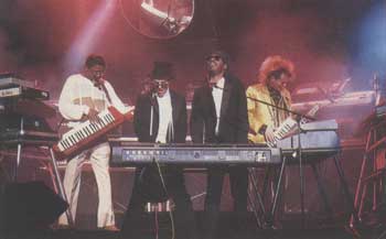 February 26: England and America join hands to rock the Grammys (L to R): Herbie Hancock on Yamaha KX1, Thomas Dolby and Stevie wonder on Kurzweil 50, and Howard Jones on Yamaha KX5.